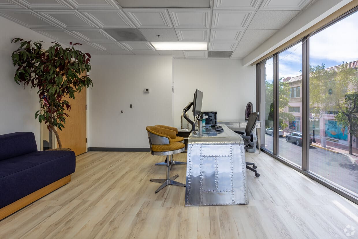 A room with a desk and chairs in it