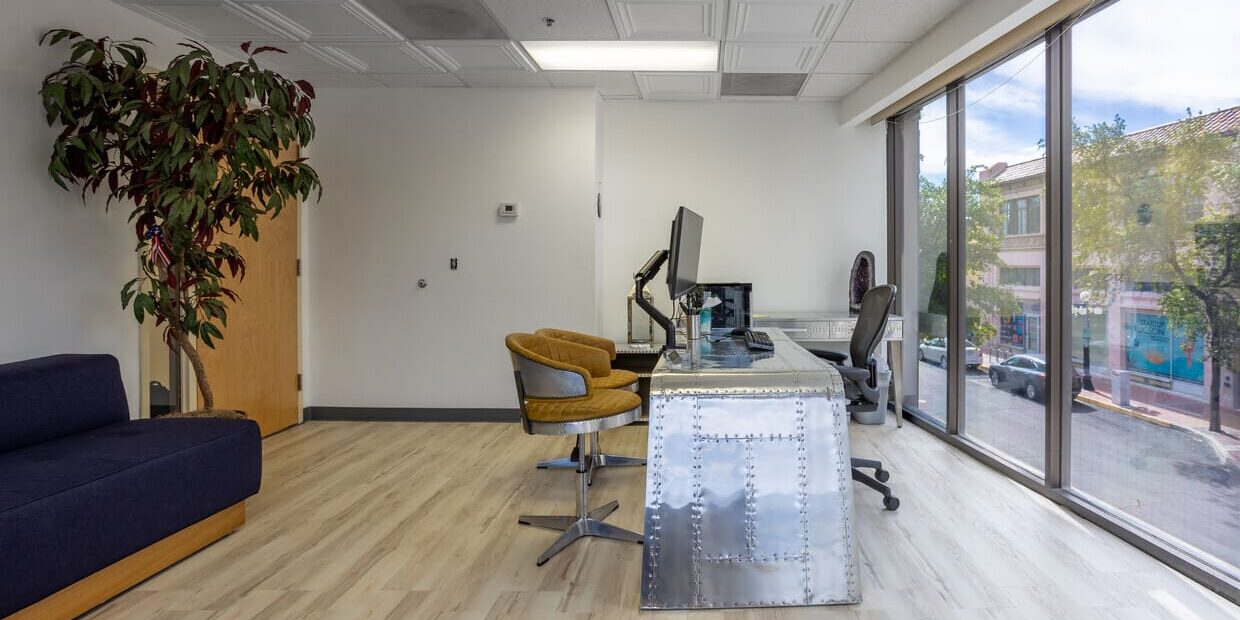 A room with a desk and chairs in it